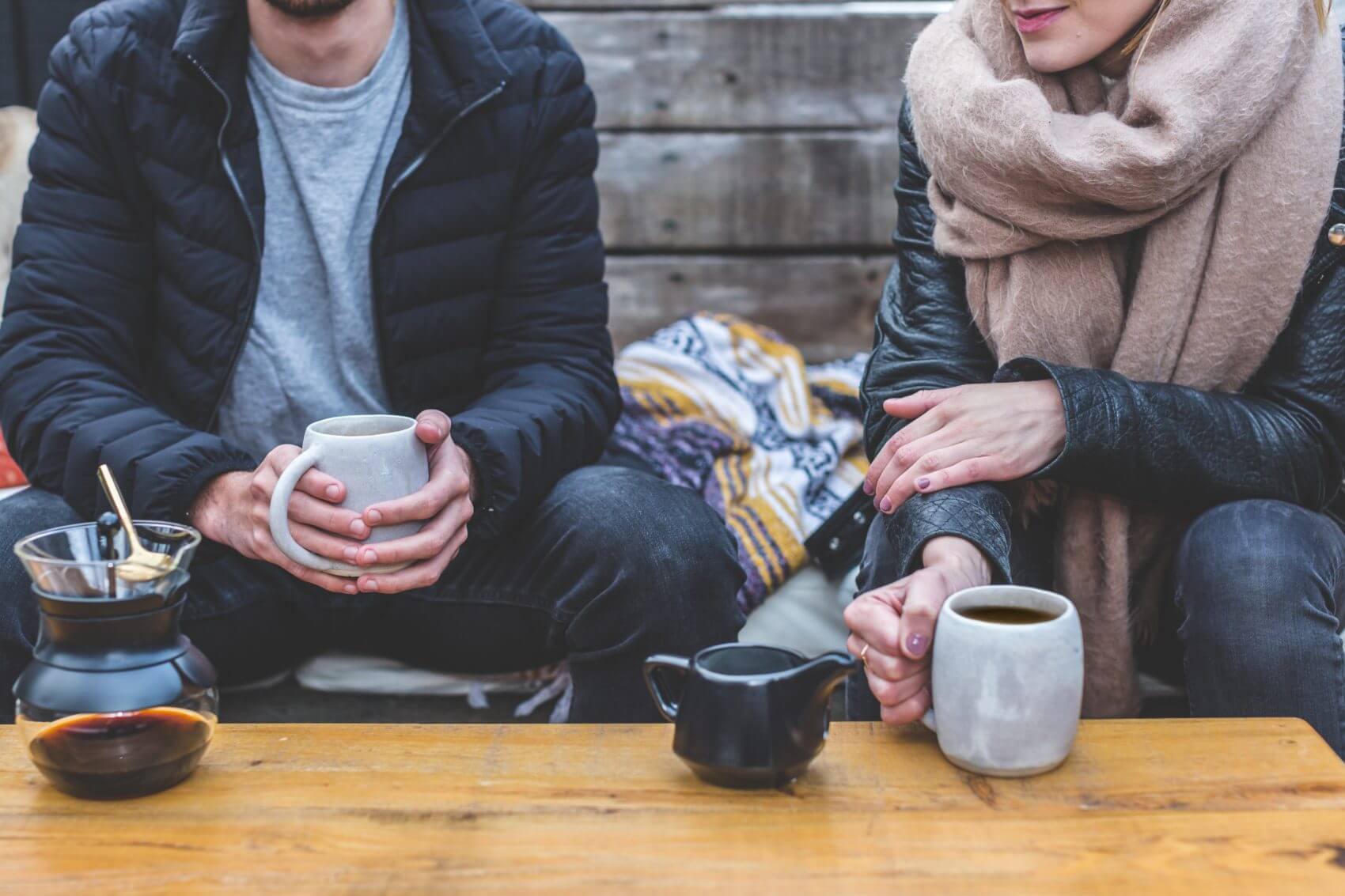 couple drinking coffee outside in chilly weather